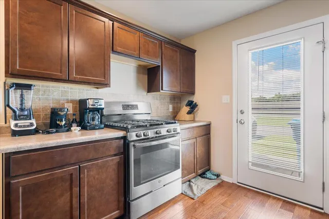 a kitchen with stainless steel appliances granite countertop a stove a sink and a refrigerator