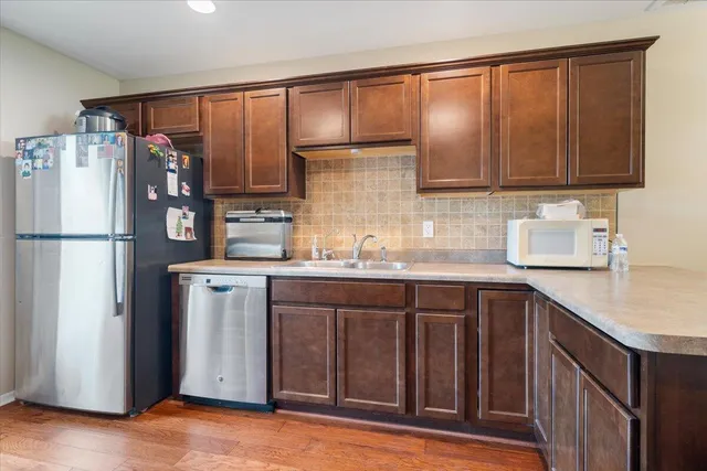 a kitchen with stainless steel appliances granite countertop a refrigerator and a sink