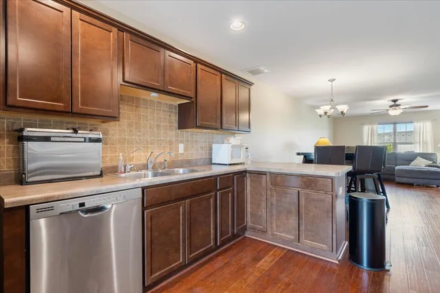 a kitchen with a sink cabinets and wooden floor