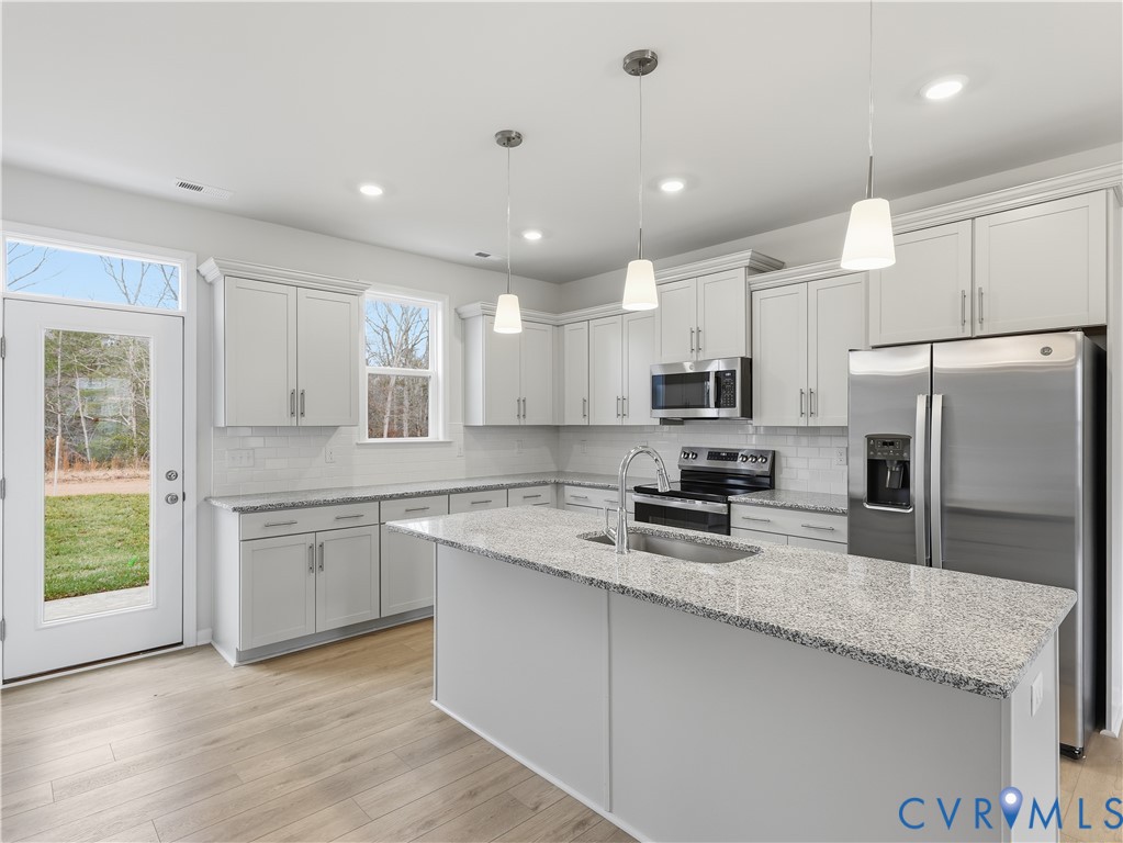 334 Mt Mccauley Way Aylett, VA 23009 - Photo 4 of 20 a kitchen with stainless steel appliances granite countertop a refrigerator a sink dishwasher a stove and white cabinets with wooden floor