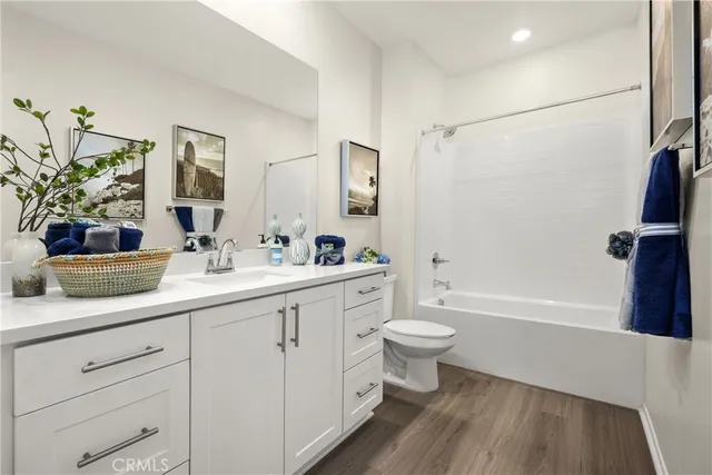 a bathroom with a double vanity sink a toilet a mirror and shower