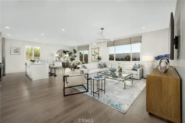 a living room with fireplace furniture and a view of kitchen