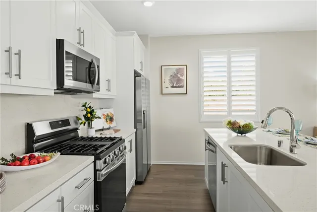 a kitchen with stainless steel appliances granite countertop a sink and a stove