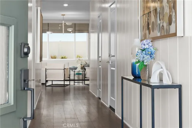 a view of a hallway with wooden floor and furniture