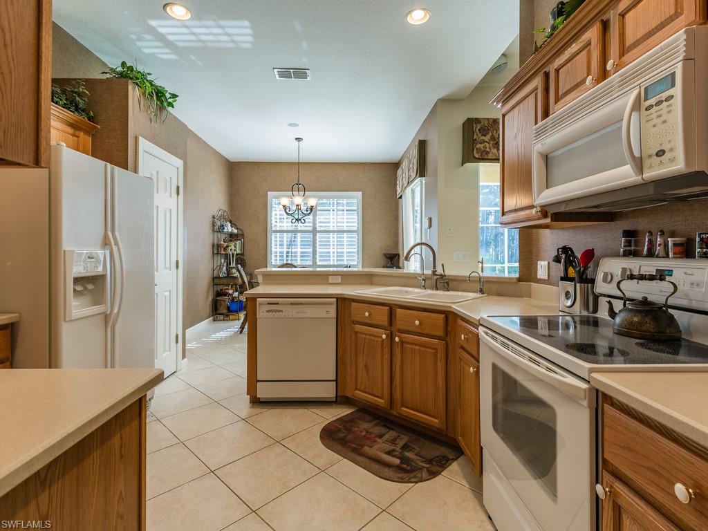 20117 Seadale Court Estero, FL 33928 - Photo 4 of 35 a kitchen with stainless steel appliances granite countertop a sink stove and refrigerator