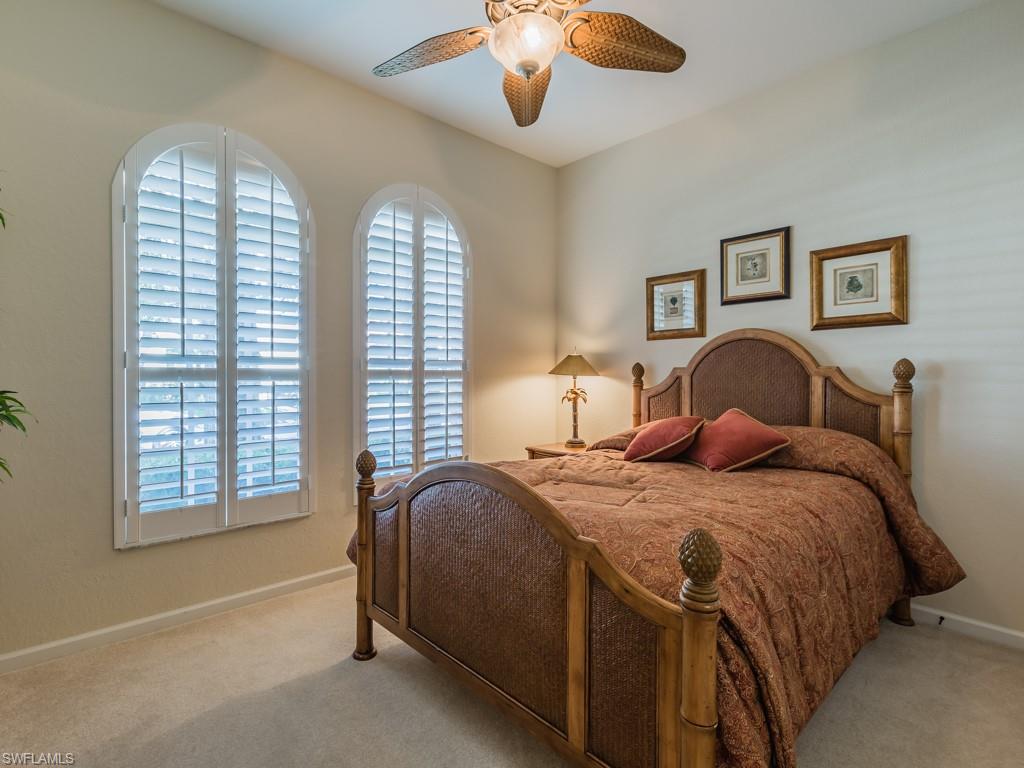 20117 Seadale Court Estero, FL 33928 - Photo 10 of 35 a bedroom with a bed and a chandelier