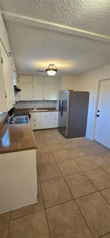 a view of a kitchen with a sink and a refrigerator
