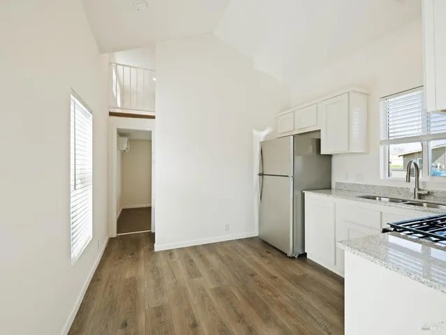 a kitchen with a refrigerator a stove top oven and white cabinets