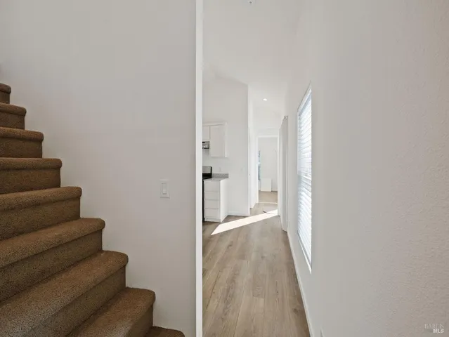 a view of a hallway with wooden floor and staircase