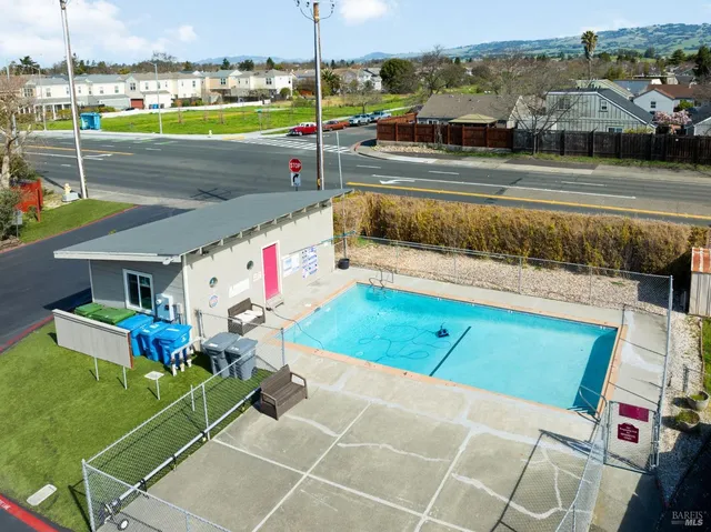 a view of a tennis ground with furniture and a table