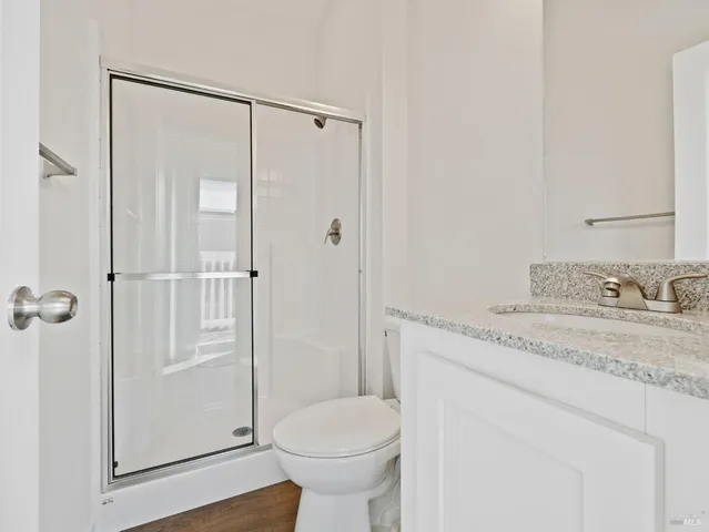 a bathroom with a granite countertop sink toilet and shower