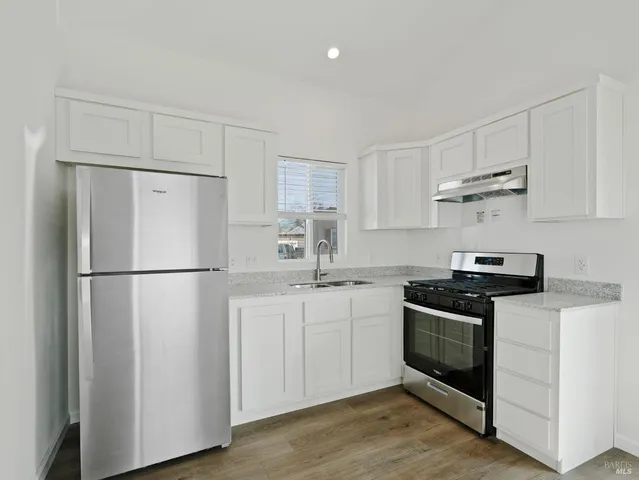 a kitchen with stainless steel appliances white cabinets and a refrigerator
