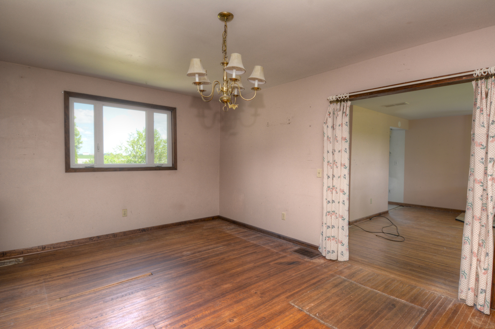 6115 South University Road Shabbona, IL 60550 - Photo 22 of 37 an empty room with wooden floor chandelier and windows