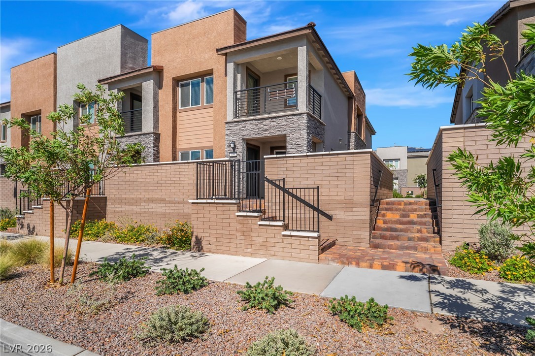 894 Cadence View Way Henderson, NV 89011 - Photo 1 of 23 Modern townhome facade featuring a second-story balcony and tasteful mixed-material construction.