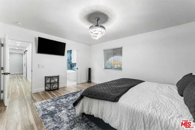 a bedroom with a large bed and a flat screen tv