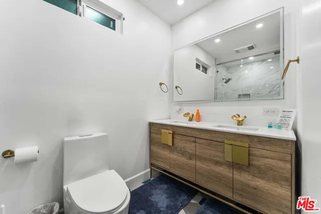 a bathroom with a sink mirror vanity and toilet