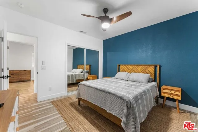 a bedroom with a bed and wooden floor