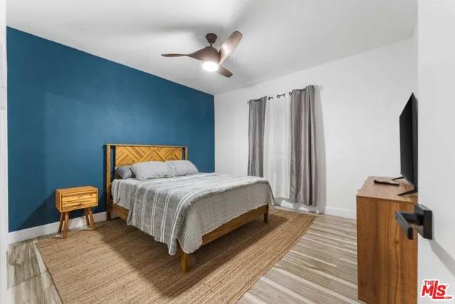 a bedroom with a bed and wooden floor