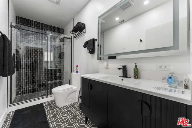 a bathroom with a sink toilet a mirror and shower