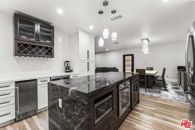 a kitchen with stainless steel appliances granite countertop a stove a sink and a refrigerator