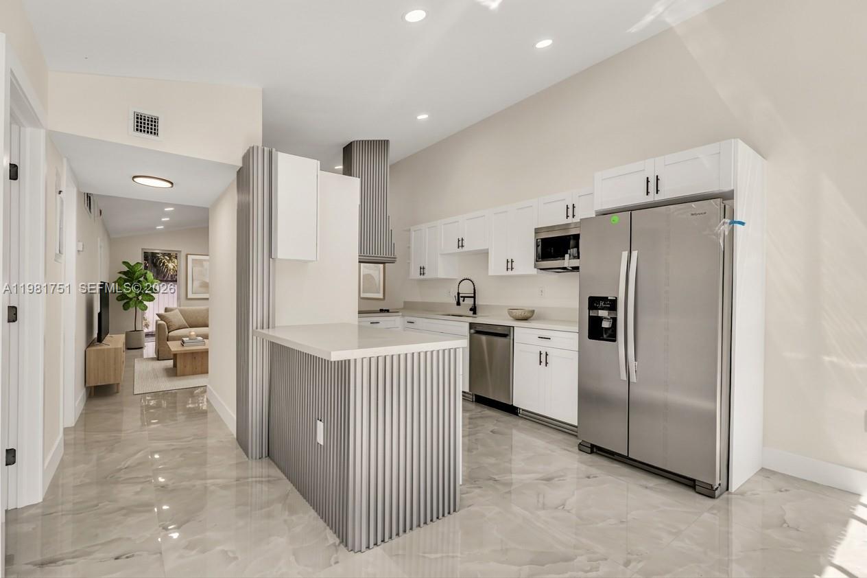 9332 Southwest 132nd Street Miami, FL 33176 - Photo 2 of 16 a kitchen with a refrigerator a sink and a stove top oven