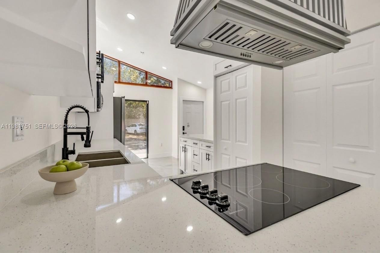 9332 Southwest 132nd Street Miami, FL 33176 - Photo 5 of 16 a kitchen with stainless steel appliances kitchen island granite countertop a sink and white cabinets
