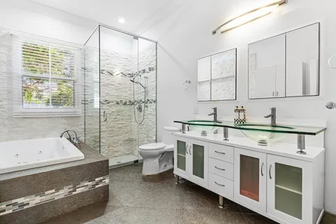 a spacious bathroom with a double vanity sink a mirror and a bathtub