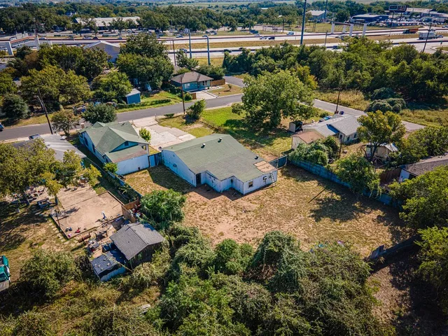 an aerial view of a house with a yard and lake view