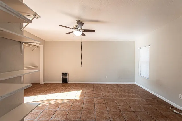 a view of empty room with a ceiling fan