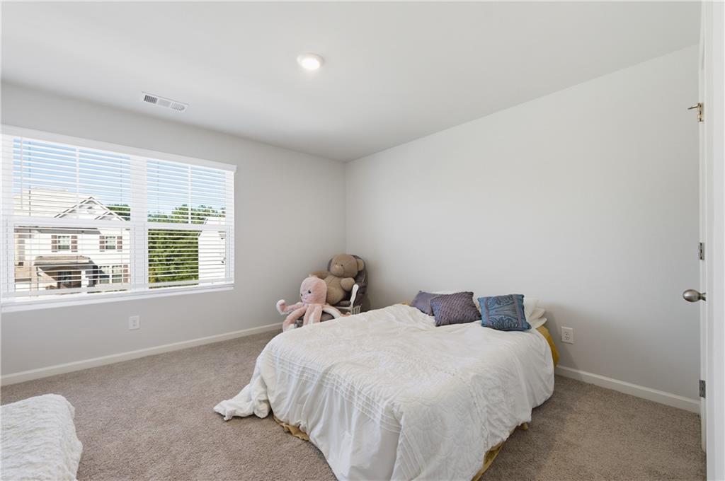7565 Jennadee Drive Fairburn, GA 30213 - Photo 22 of 42 a bedroom with a bed and a window