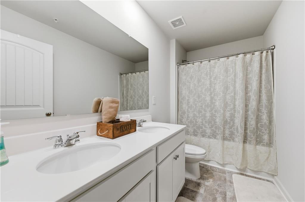 7565 Jennadee Drive Fairburn, GA 30213 - Photo 23 of 42 a bathroom with a sink toilet and shower