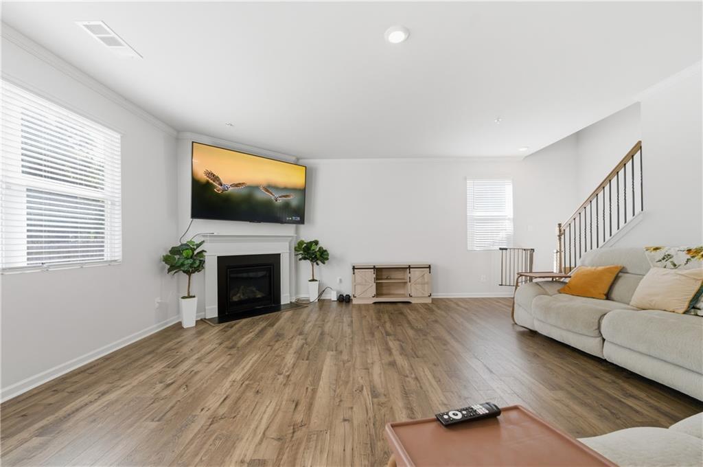 7565 Jennadee Drive Fairburn, GA 30213 - Photo 5 of 42 a living room with furniture a fireplace and a flat screen tv