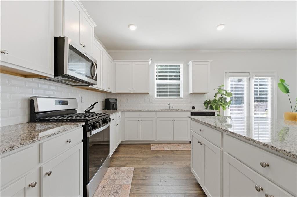 7565 Jennadee Drive Fairburn, GA 30213 - Photo 10 of 42 a kitchen with stainless steel appliances granite countertop a sink and stove top oven