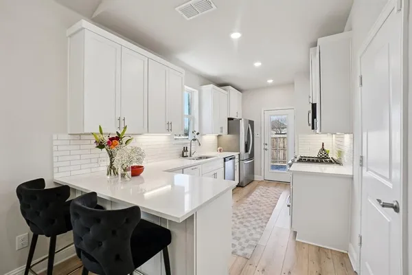 a kitchen with stainless steel appliances kitchen island granite countertop a sink and cabinets