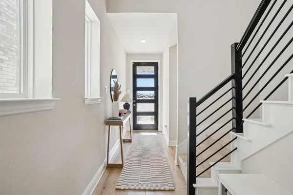 a view of a hallway with wooden floor and staircase