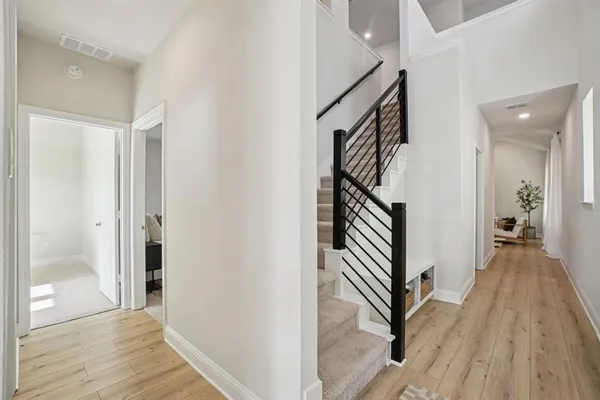 a view of a hallway with wooden floor and staircase