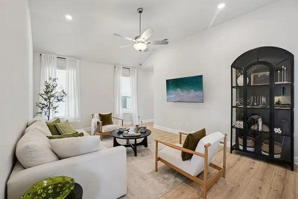a living room with furniture a rug and a bookshelf