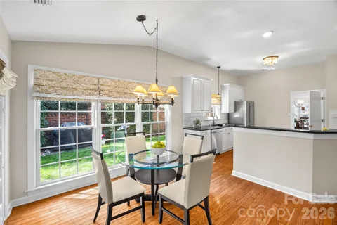 a view of a dining room with furniture wooden floor and a chandelier