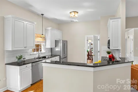 a kitchen with stainless steel appliances a sink a refrigerator and cabinets