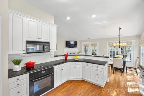 a kitchen with granite countertop a sink cabinets and stainless steel appliances