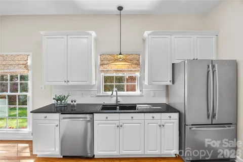 a kitchen with granite countertop a refrigerator and a sink