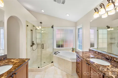 a spacious bathroom with a granite countertop sink mirror and a bathtub