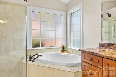 a bathroom with a granite countertop sink and a bathtub