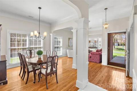 a view of a dining room and livingroom with furniture wooden floor a chandelier