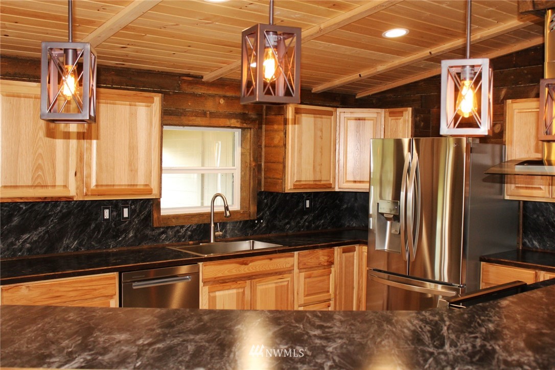 18337 Forstrom Street Southwest Rochester, WA 98579 - Photo 4 of 26 a kitchen with granite countertop a refrigerator and a sink