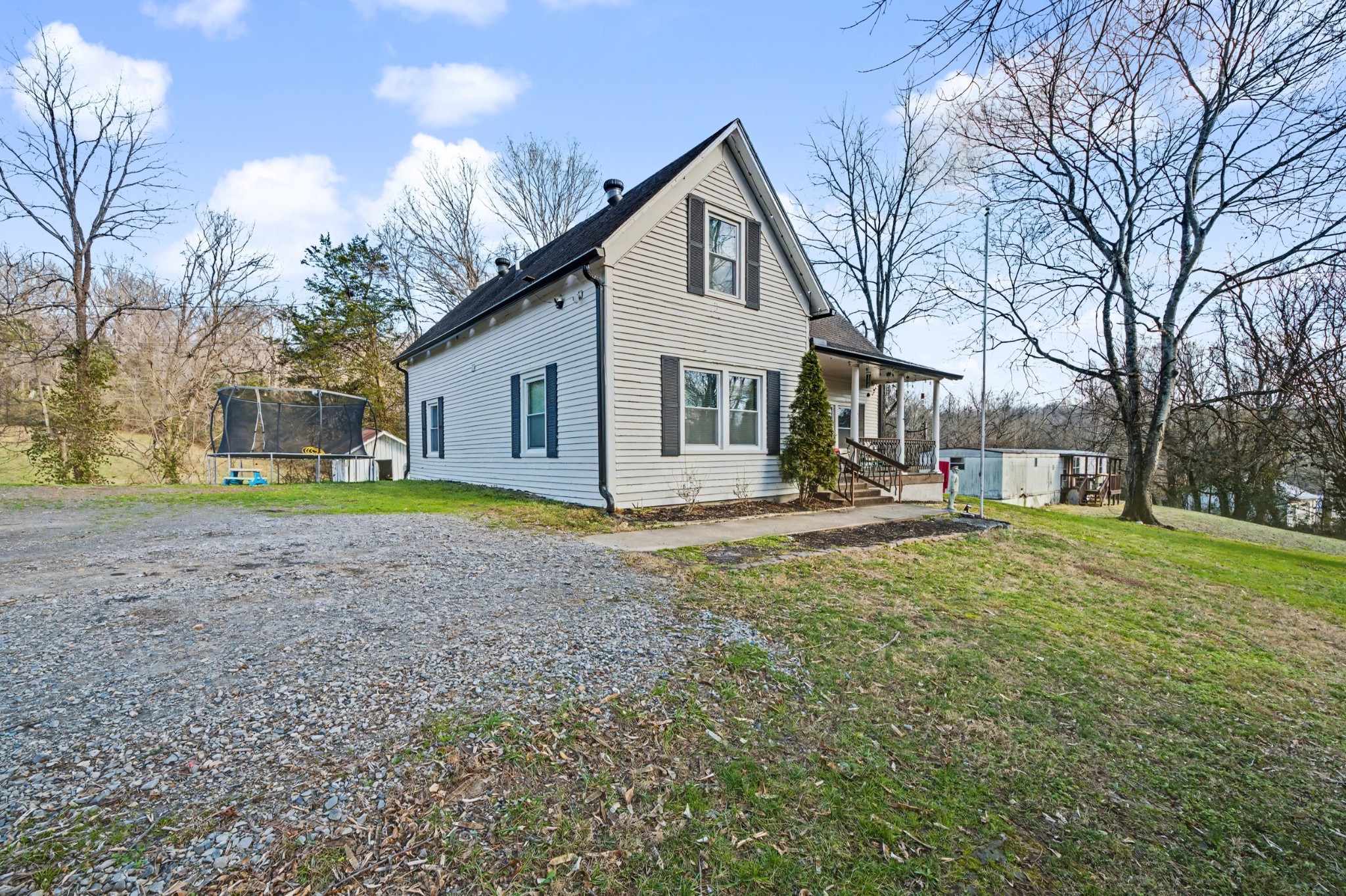 116 Tracy Academy Street Charlotte, TN 37036 - Photo 2 of 36 a view of a house with a yard and large trees