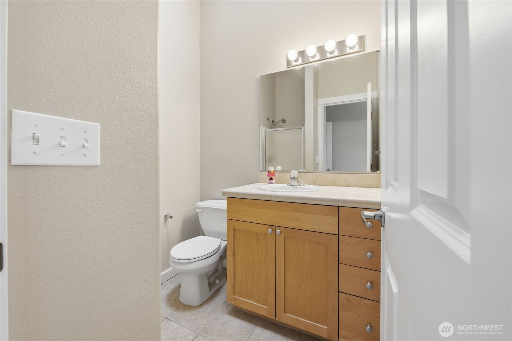 210 North G Street, Unit D Tacoma, WA 98403 - Photo 16 of 19 a bathroom with a sink a toilet and a mirror