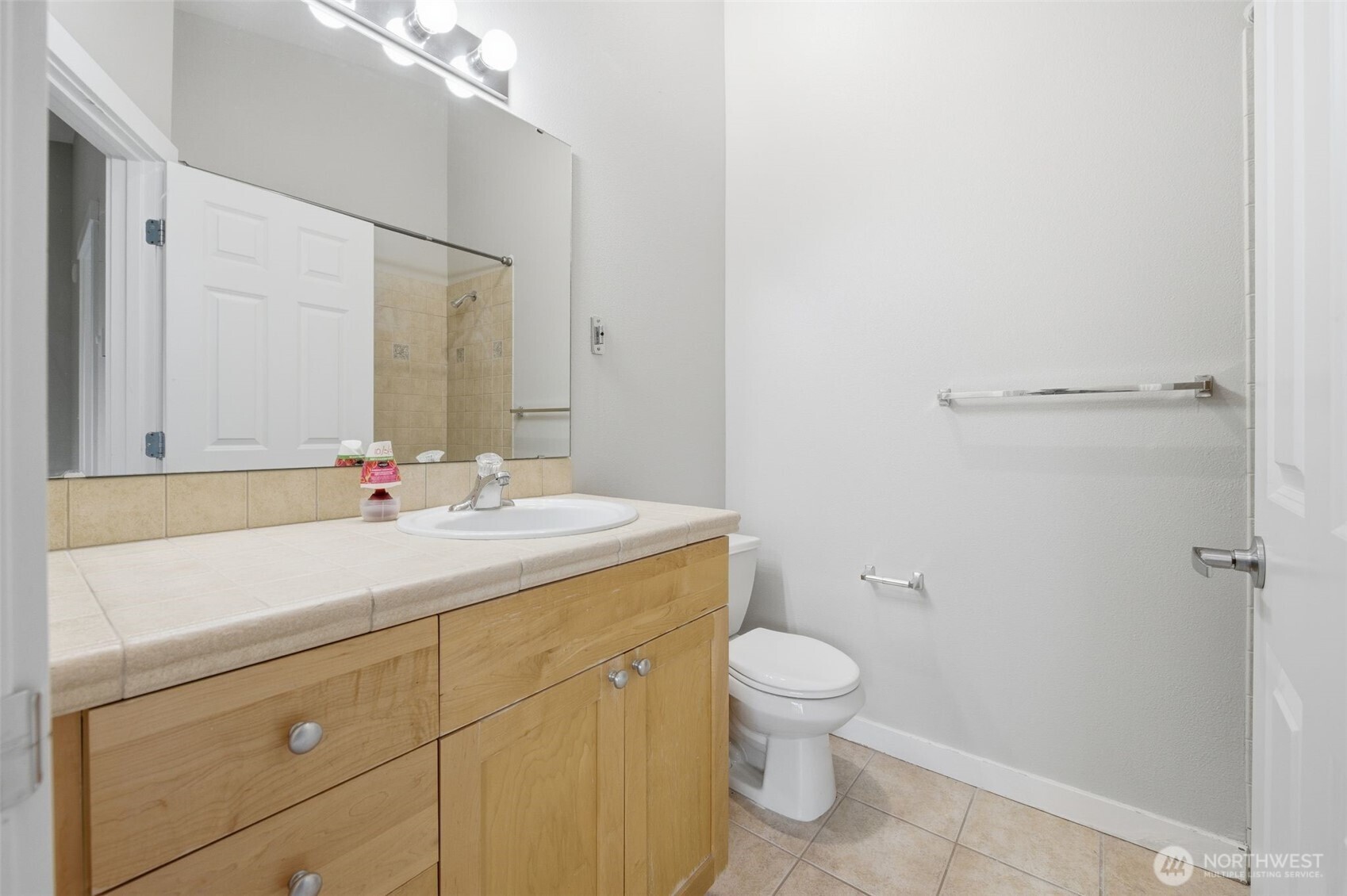 210 North G Street, Unit D Tacoma, WA 98403 - Photo 17 of 19 a bathroom with a sink a toilet and a mirror