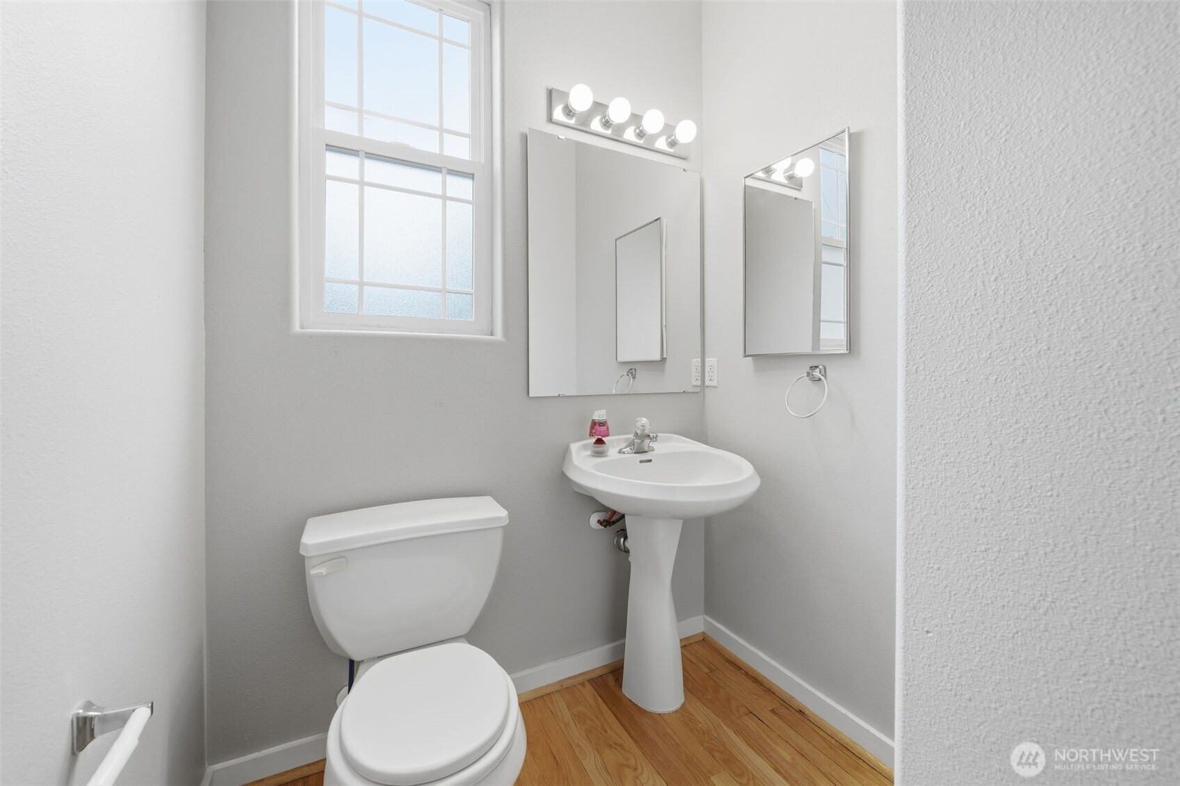 210 North G Street, Unit D Tacoma, WA 98403 - Photo 19 of 19 a bathroom with a toilet sink and mirror