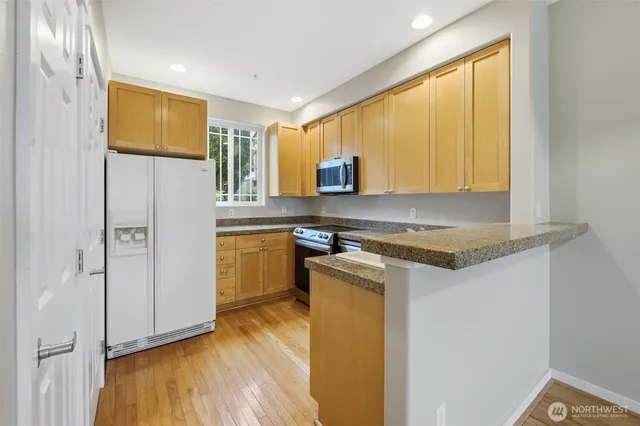 a kitchen with stainless steel appliances granite countertop a stove a sink and a refrigerator